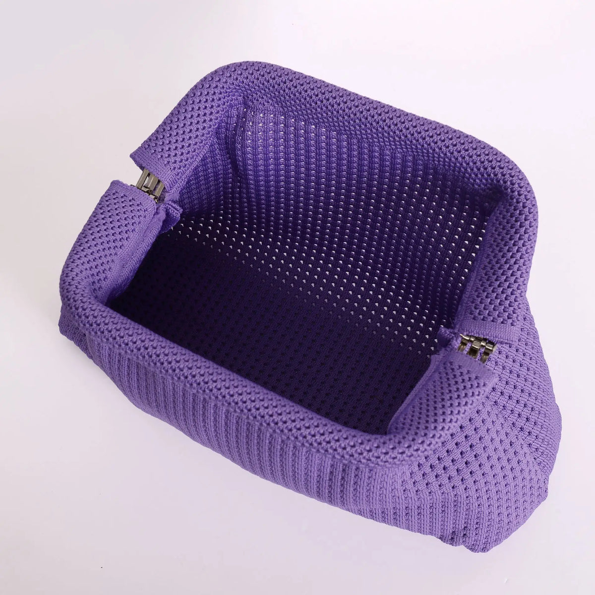 A purple knitted clip bag with a textured surface and metal clasps.