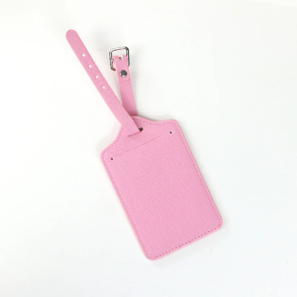 A pink PU leather luggage tag with a silver clip attached to a pink strap.