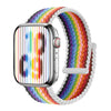 A silver Apple Watch is shown with a colorful braided stretch band wrapped around it.