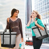 A blonde woman carrying a black insulated cooler bag while walking in an urban setting.