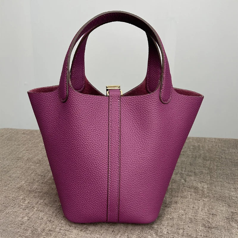A deep purple genuine leather bucket bag with a smooth texture and gold hardware.