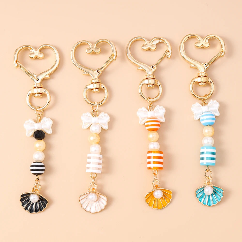 Gold-toned starfish and seashell keychain with pearl and striped accents