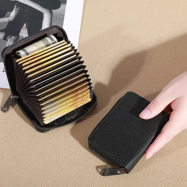 A black PU leather card and ID holder wallet is shown open, displaying several stacked cards and a rolled-up document on a be