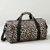 Maleta de viaje tipo duffel con estampado de leopardo, correas negras y compartimento para zapatos.