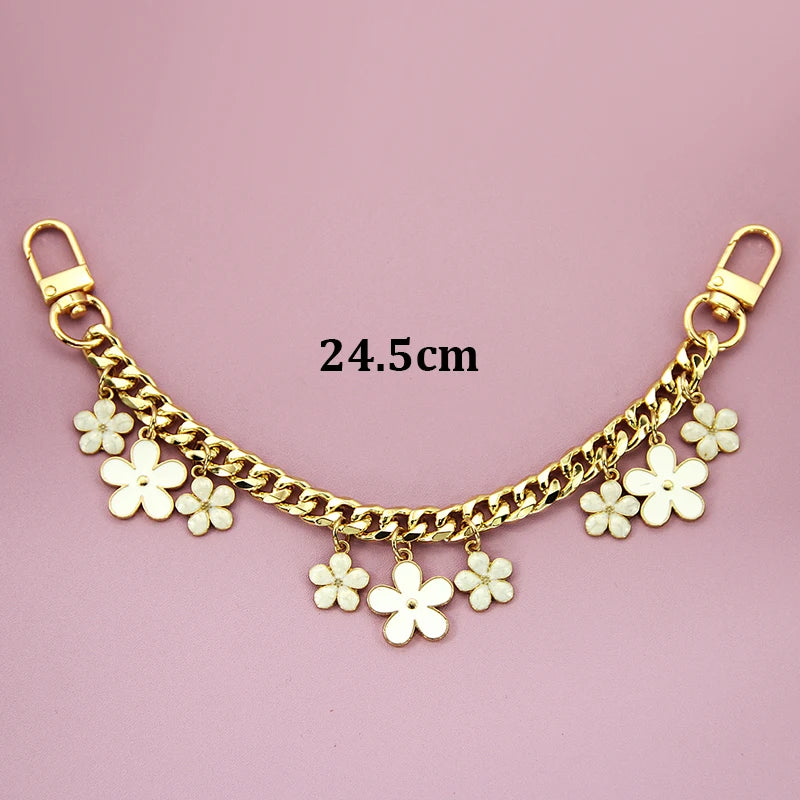 Gold chain necklace with white flower charms and a gold clasp, measuring 24.5cm.