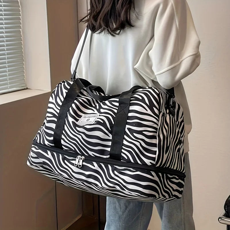 A white and black zebra-striped nylon travel duffle bag carried by a person.