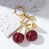 Gold-toned keychain featuring a shiny red crystal cherry fruit charm.