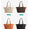Four quilted tote bags in camel, brown, orange, and black colors displayed side by side.