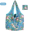 A reusable eco tote shopping bag featuring a vibrant floral print of pink and blue flowers on a light blue background.