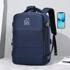 A navy blue expandable travel backpack with a black strap and a smartphone charging cable is displayed on a light surface.