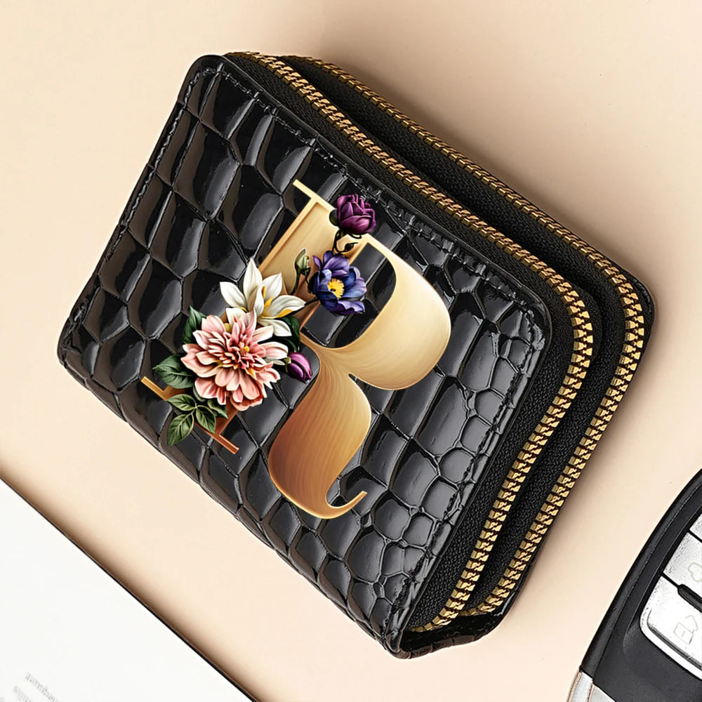 A black PU leather double-zip clutch wallet featuring a gold-toned cartoon print of a flower.