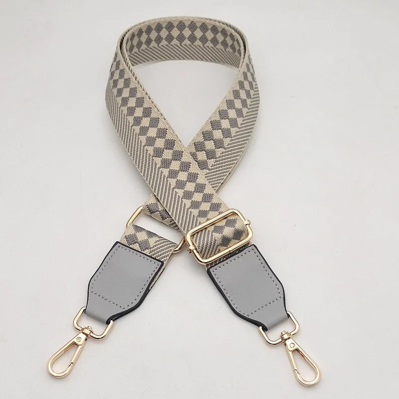 A beige and gray checkered braided nylon strap for a bag, featuring gold-toned metal hooks.