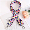 A colorful floral patterned adjustable crossbody strap laid across a white notebook.