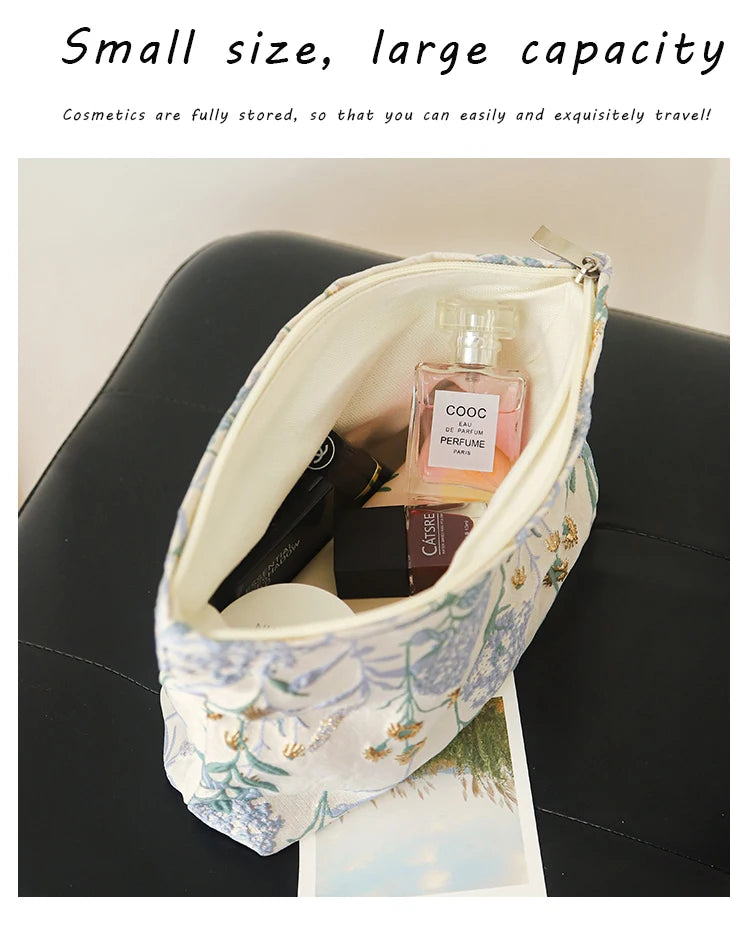 A light blue floral canvas makeup bag is open, showing a glass perfume bottle and other cosmetics inside.