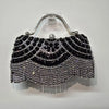 Black diamond rhinestone evening clutch bag with a golden tassel hanging from a silver loop.