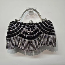 Black diamond rhinestone evening clutch bag with a golden tassel hanging from a silver loop.