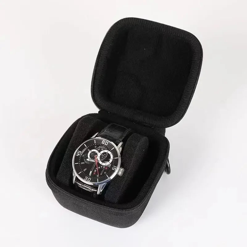 Black multi-slot travel watch organizer case with soft lining and a wristwatch inside.