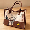 A brown canvas shoulder bag featuring a Snoopy cartoon design on the front.