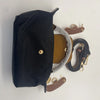 Black waterproof nylon crossbody bag with a tan leather pouch and gold hardware.