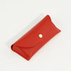 A red PU leather hard shell sunglasses case with a gold-colored stud closure.