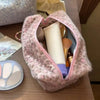Una bolsa de almacenamiento con cremallera de piel sintética rosa abierta, revelando diversos artículos de maquillaje dentro.