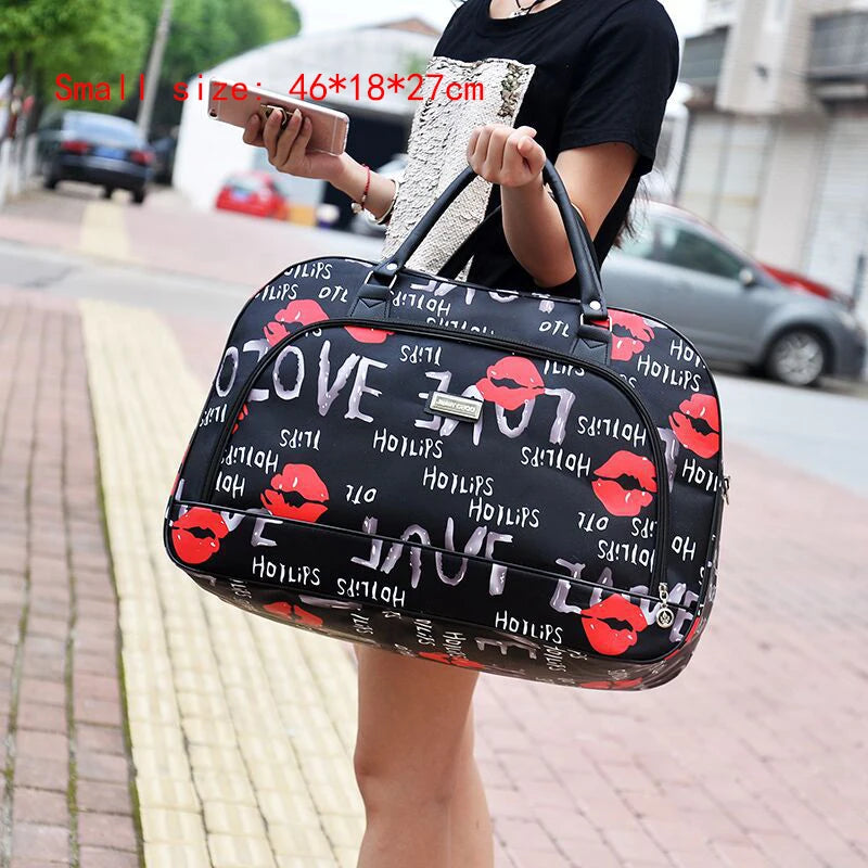 شخص يحمل حقيبة سفر سوداء عليها تصميم لـ LOVE بتركيز على الشفاه الحمراء ونص عليها.