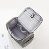 A gray portable Oxford cloth toiletry bag is shown open, displaying a padded interior and a mesh lining.