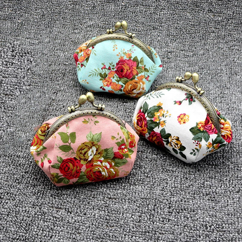 Two vintage rose print canvas coin purses, one light blue and one pink, resting on a gray textured surface.