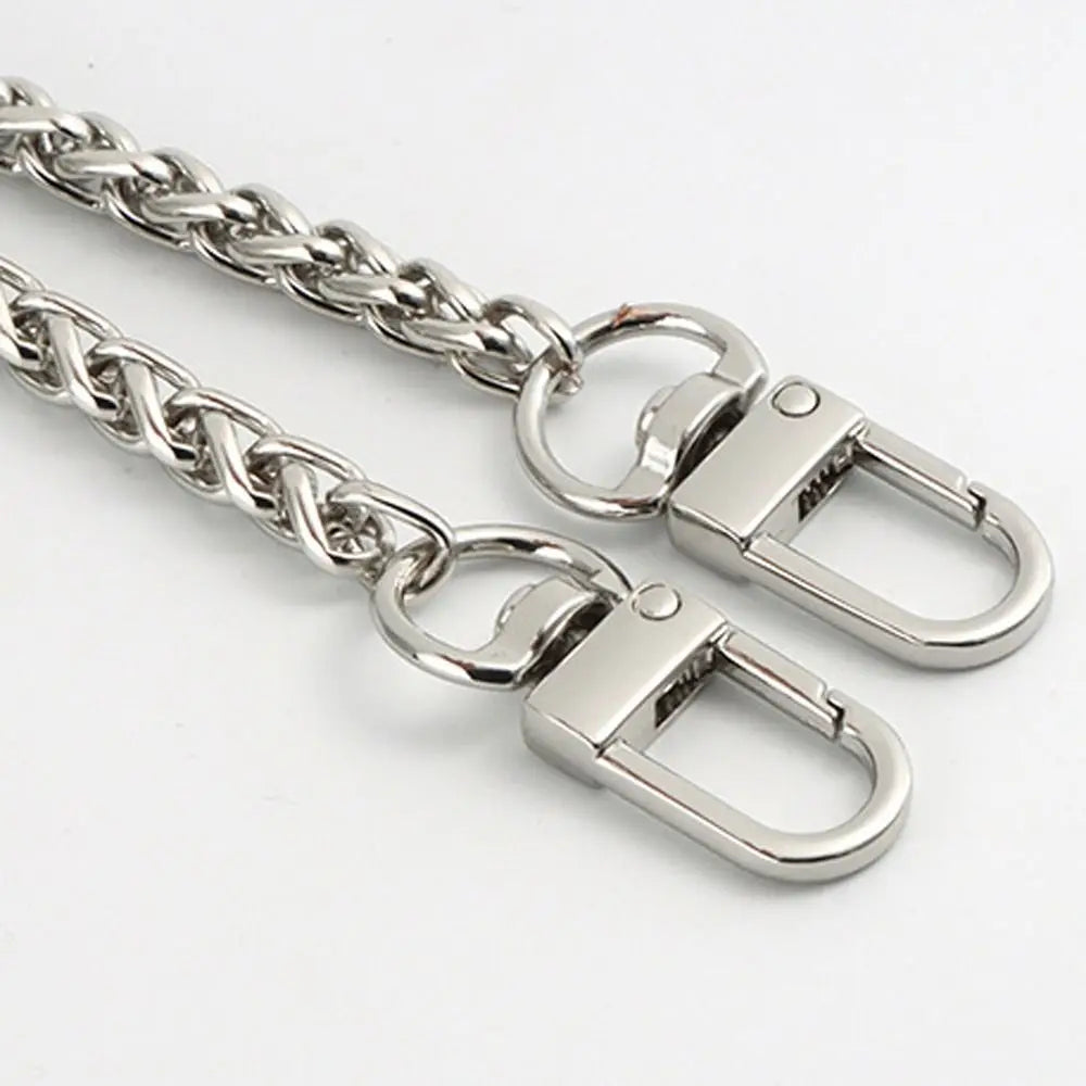 Cartera de metal plateada con cadena y cierre de langosta y anillo de salto.