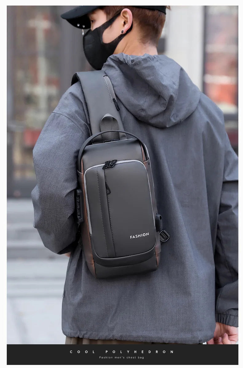 A man wearing a gray hoodie carries a dark gray anti-theft zippered crossbody bag.