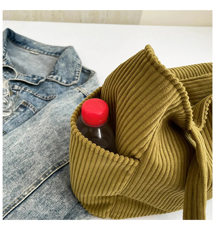 A mustard green corduroy fabric is shown folded around a glass bottle on a white surface.