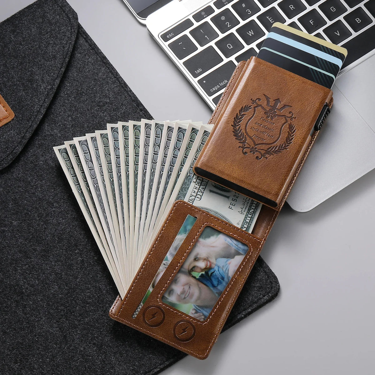 A brown PU leather card holder with a leather sleeve and a clear plastic window is shown next to a laptop and a stack of US d