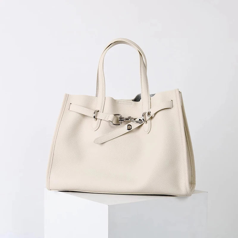 A cream-colored genuine leather women's shoulder tote bag with a light beige canvas handle.