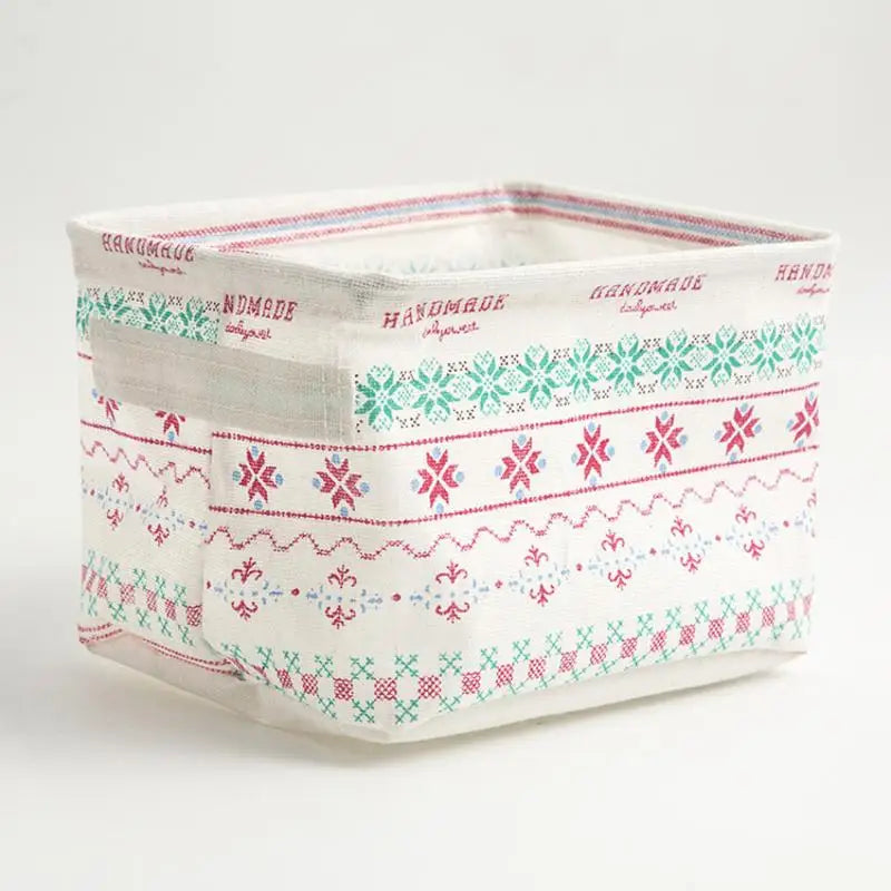 A white waterproof cotton linen storage basket with pink and green embroidered patterns.