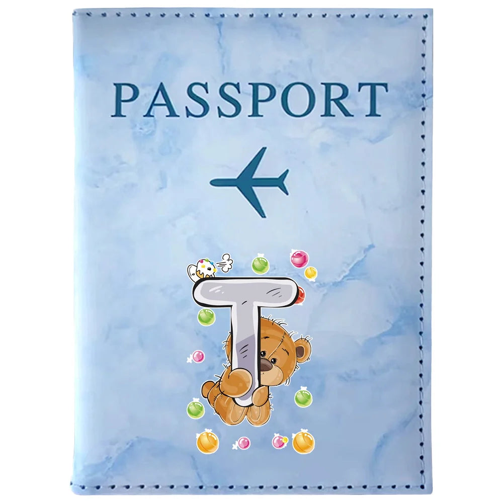 Light blue passport card holder featuring a stylized letter T and a teddy bear design
