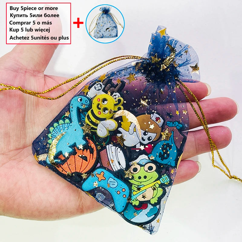 A hand holds a decorative shoe charm made of blue and gold fabric with various animal and geometric pins.
