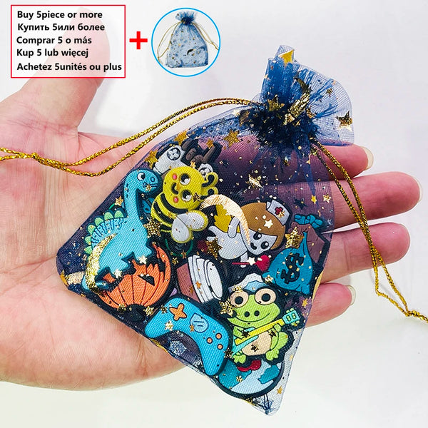 Eine Hand hält einen dekorativen Schuhcharm aus blauem und goldenem Stoff mit verschiedenen Tier- und geometrischen Pins.