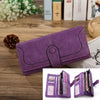 A purple PU leather clutch wallet with RFID protection lying on a wooden surface.