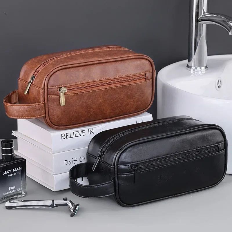 A brown leather travel cosmetic bag and a black leather travel cosmetic bag are shown next to a sink.
