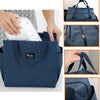Bolsa de almuerzo de lona aislada azul oscuro mostrada desde varios ángulos, incluyendo un primer plano de la tela y los deta