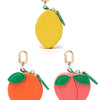 A set of three fruit-shaped coin purse keychains in yellow, orange, and pink.