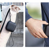 Estuche de almacenamiento negro premium para AirPods y accesorios, sujeto a una correa de mochila de color claro.