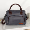 A black and white striped thermal storage bag with brown leather handles and trim.