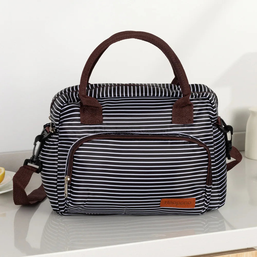 A black and white striped thermal storage bag with brown leather handles and trim.