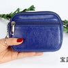 A hand holds a dark blue PU leather mini wallet with a silver keychain against a white background.