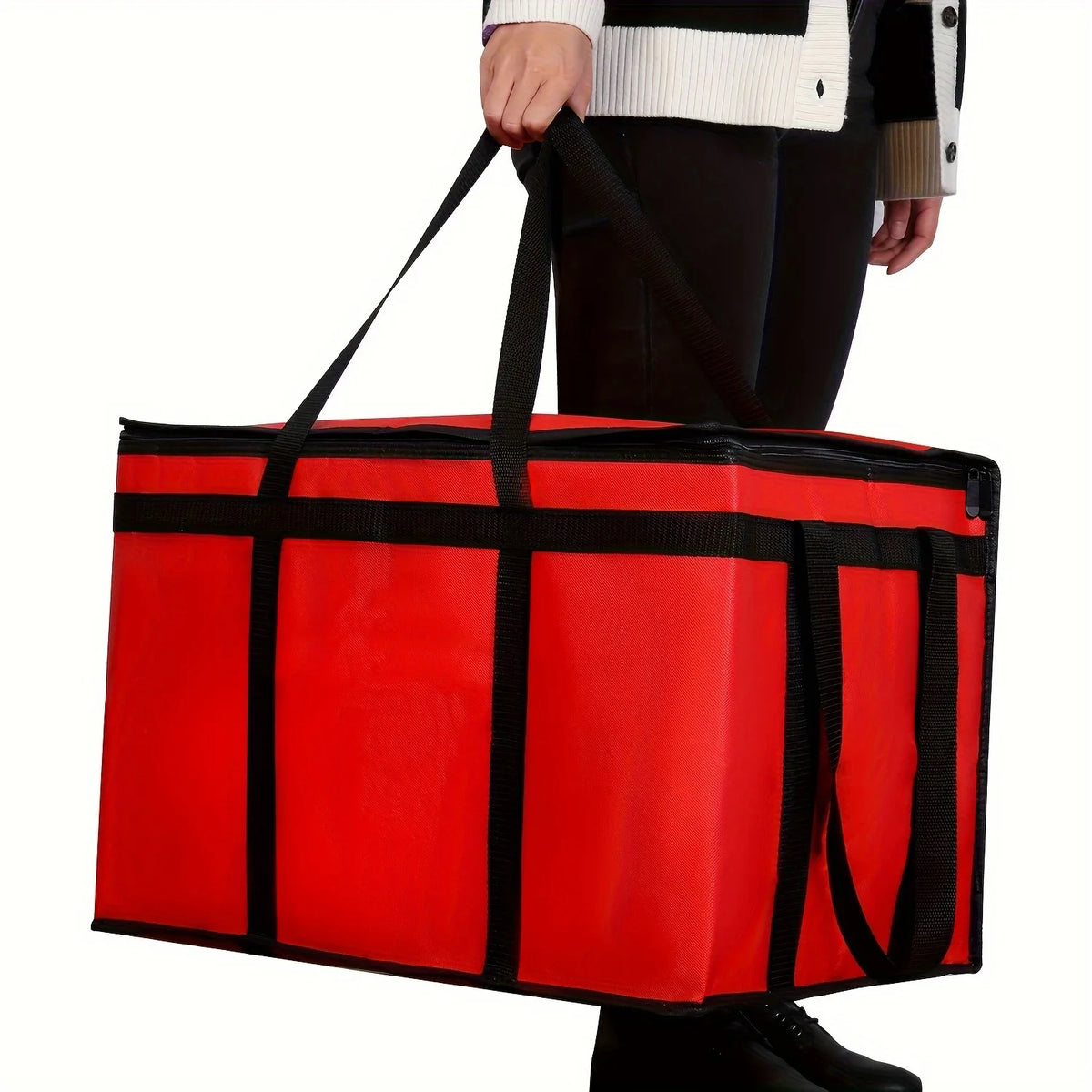 A bright red reusable insulated warming bag with black trim and handles being held by a person.