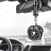 A black alloy wheel hub brake disc pendant hangs from a chain and is positioned in front of a car's rearview mirror.