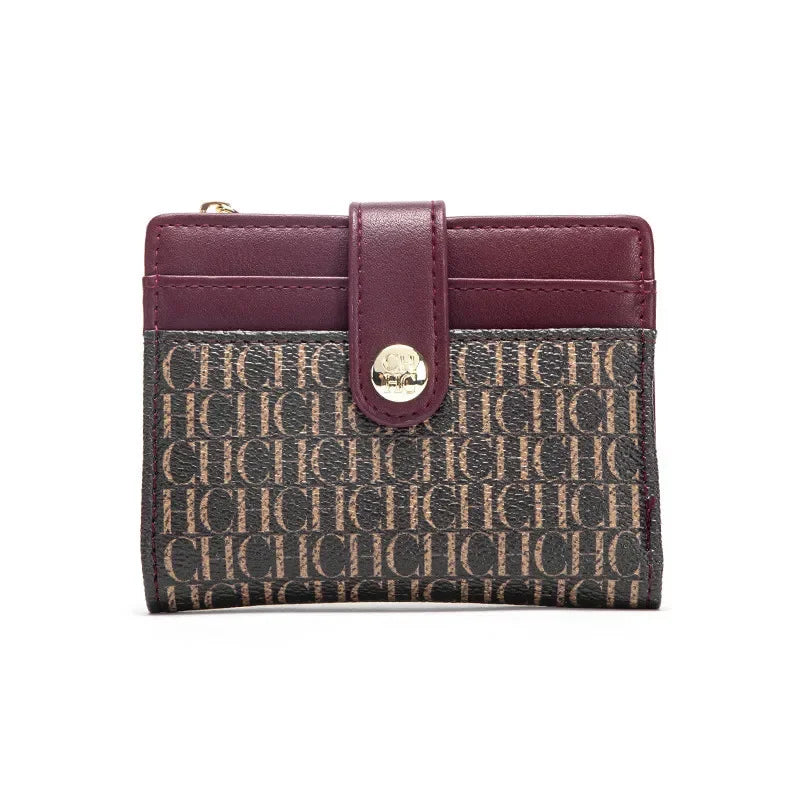 A maroon folding wallet with a leather strap and patterned fabric exterior.