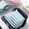 A collection of light blue sanitary napkins is neatly stored in a black zippered pouch alongside pink and teal storage pouche