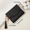 Black PU leather coin clutch wallet with a gold chain and tassel resting on a cream textured fabric.